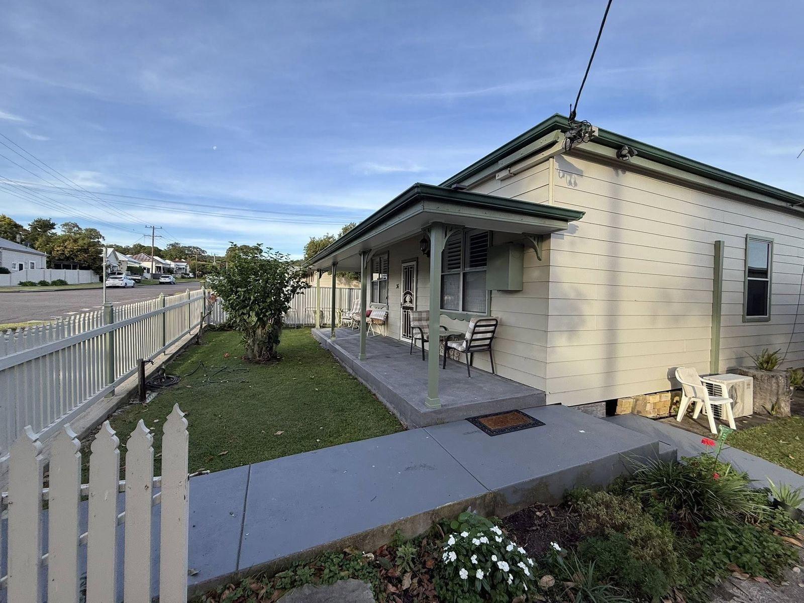 Repainted weatherboard home with white picket fence in Newcastle by Hughesys Painting